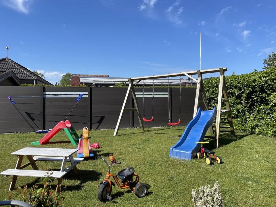 Der Garten der Villa Wunderland mit Schaukeln und Rutschen an einem sonnigen Tag